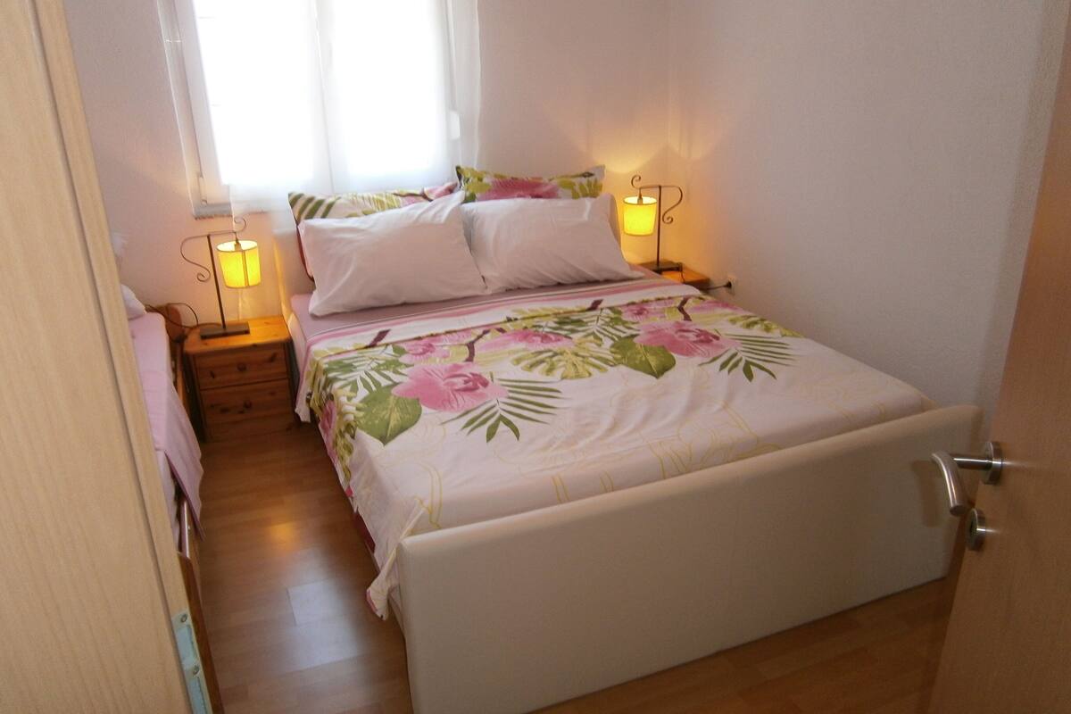 A bedroom with a bed, bedside tables, and a nightstand.