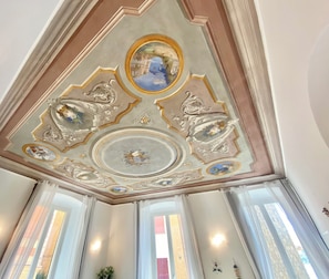 Experience the grandeur of this classic room, featuring an ornate ceiling with intricate plasterwork and a central medallion.