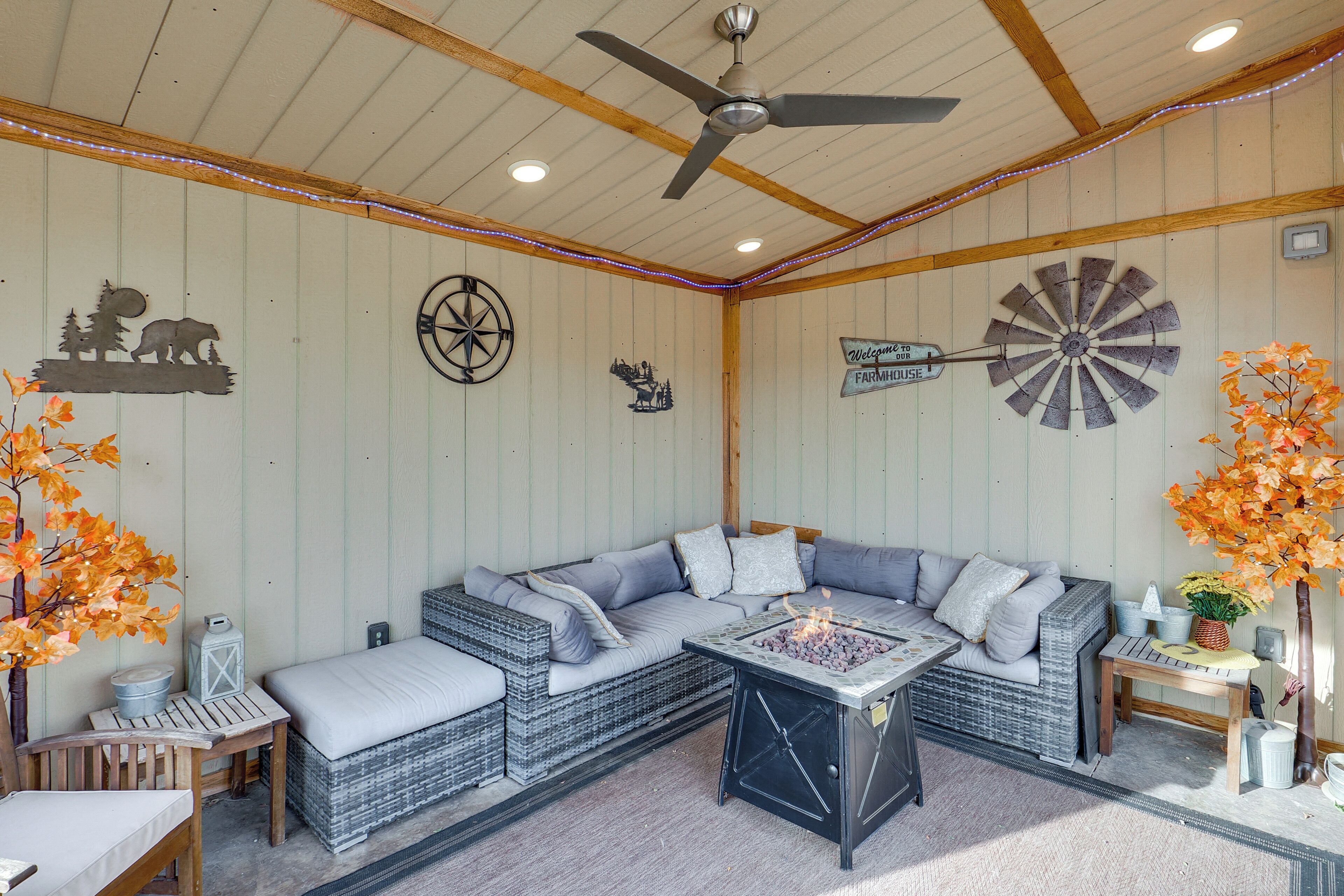 A cozy room with a sectional sofa, a fireplace, a ceiling fan, and decorative wall art.
