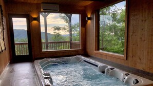 Un jacuzzi con vistas a un balcón y árboles.