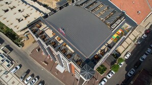 An aerial view of a hotel with a flat roof, multiple balconies, and a parking lot. - Can Deluxe Hotel (Alasehir)