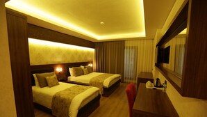 A hotel room with two beds, a desk, and a large mirror. - Can Deluxe Hotel (Alasehir)