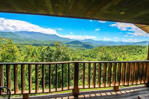 A wooden deck with a view of a mountainous landscape.