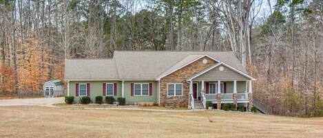 A two-story house with a front porch, a small attached garage, and a well-maintained lawn.