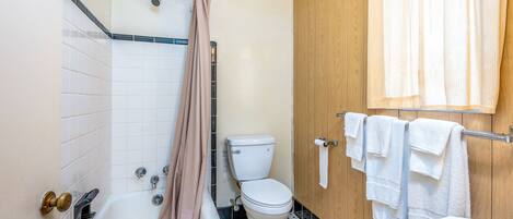 Un baño con bañera, inodoro y lavamanos.