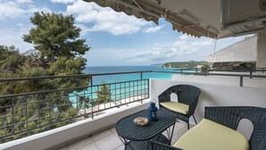 Un balcone con mobili in vimini, vista mare e piscina.