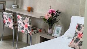 Ein Zimmer mit einem Bett, einem Schreibtisch mit Stühlen, einer Uhr, einer Klimaanlage und einer Dekoration in Form eines Sterns.