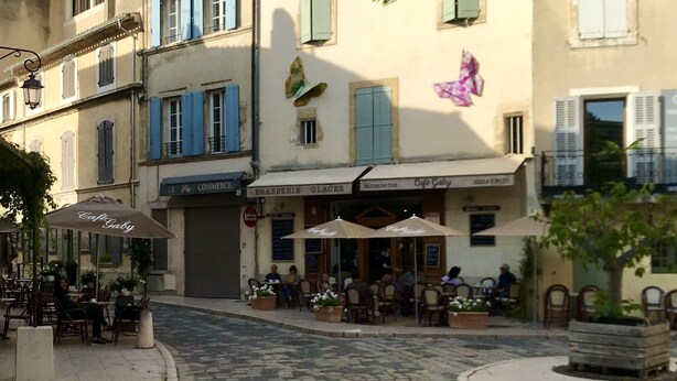 Una strada acciottolata con tavolini all'aperto al Caffè Gaby.