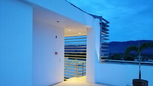 A modern building with a staircase leading to an upper level, a potted plant, and a view of distant mountains. - Hotel Rupert A Baler (Baler)