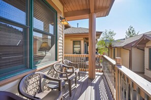 A wooden deck with outdoor furniture, a covered area, and a view of neighboring buildings. - Greyhawk 3BR | Lower Deer Valley | Private Hot Tub | Walk to Main Street (Park City)