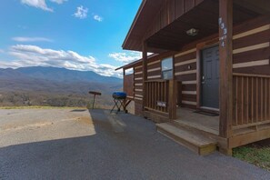 A cabin with a wooden exterior, a front door, and a number sign.