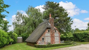 A traditional thatched-roof house with a brick base, surrounded by a well-maintained lawn and hedges. - 2 bedroom accommodation in Cheriton (Cheriton)