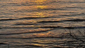 A sunset over a calm sea with a clear horizon.