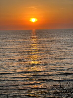 A sunset over a calm sea with a clear horizon.