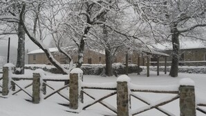 A snow-covered outdoor area with stone walls and a wooden fence. - Il Canalotto (Longi)