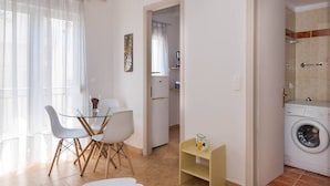 Un appartement moderne comprenant un coin repas, une cuisine et une buanderie.