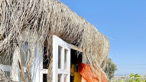 A rustic building with a thatched roof, a reception sign, and a large terracotta pot. - Alacati Barbarossa Hotel (Cesme)