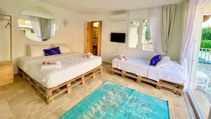A bedroom with two beds, a large mirror, a TV, and a view of the outdoors. - Alacati Barbarossa Hotel (Cesme)