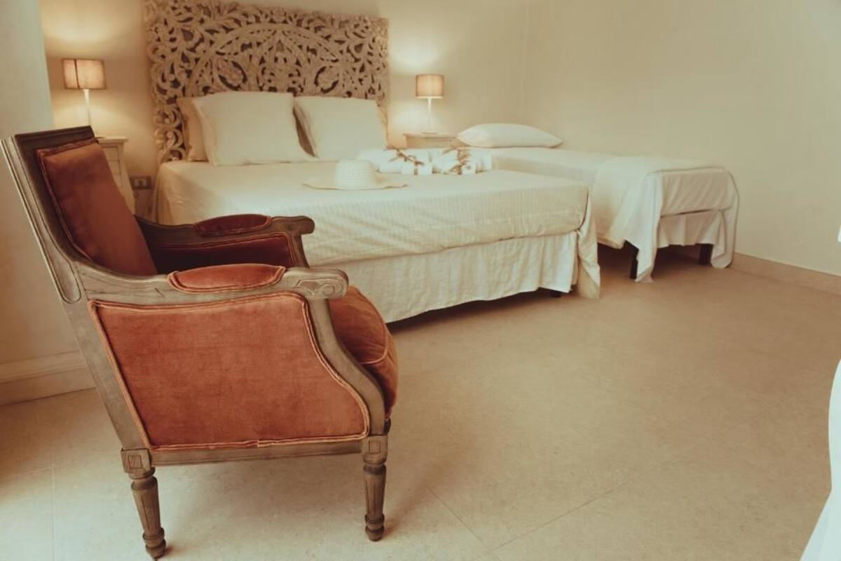 Ein Schlafzimmer mit einem großen Bett, einem Sessel und einem Nachttisch.