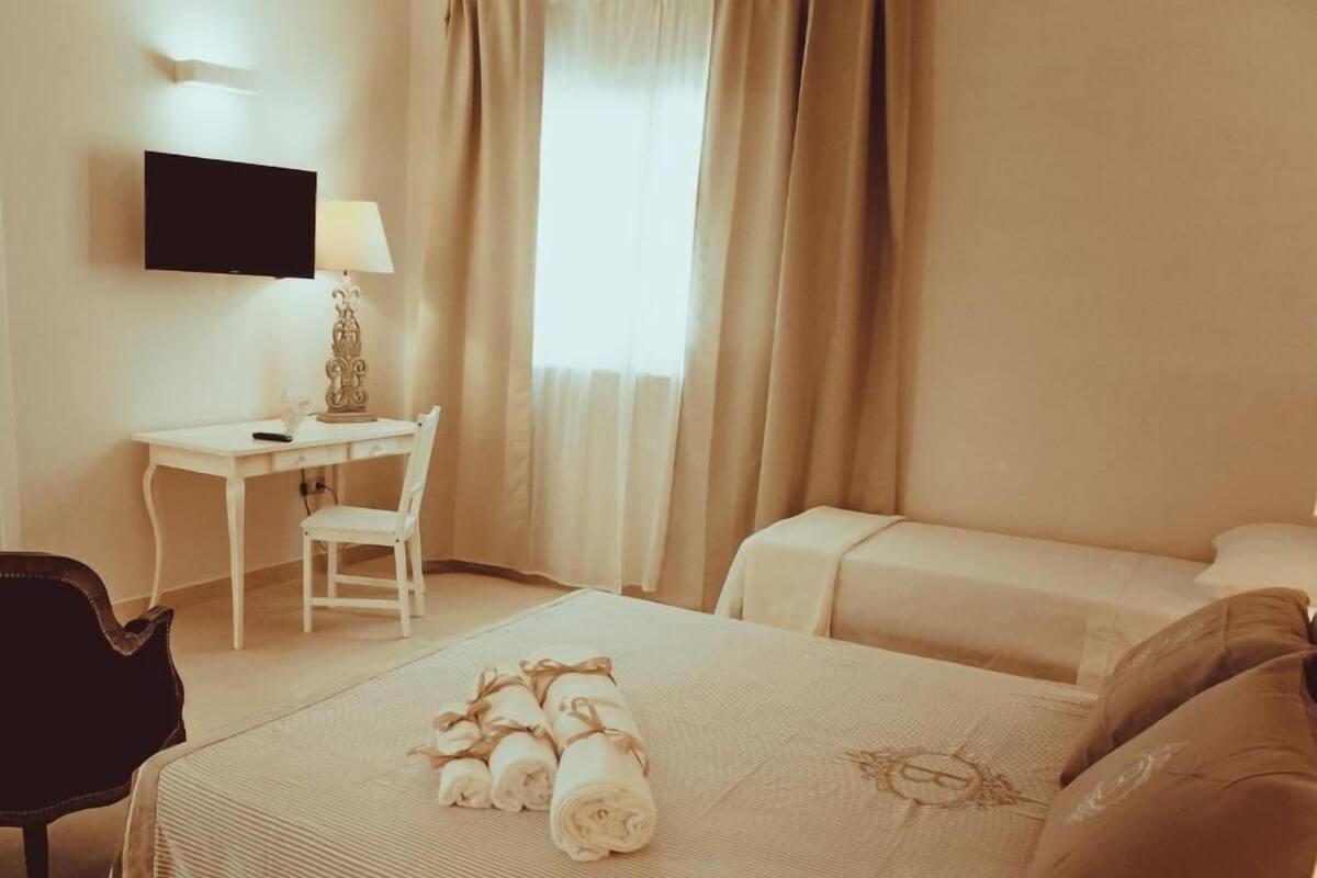 Ein Hotelzimmer mit Bett, Schreibtisch, Stuhl und Fernseher.