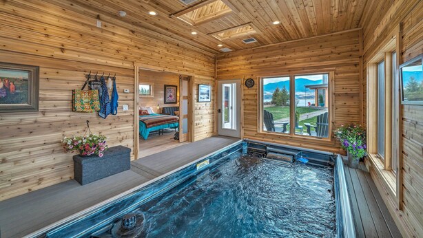A wooden cabin with a hot tub, wooden walls, and a view of the outdoors. - Ennis Lake Studio w/ Kayak, Pool & Fire Pit! (McAllister)
