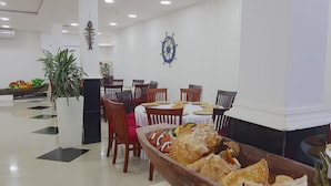 A dining area with a wooden boat filled with seashells, white walls, and ceiling lights. - Hotel Boutique Campanario del Río (Soledad)