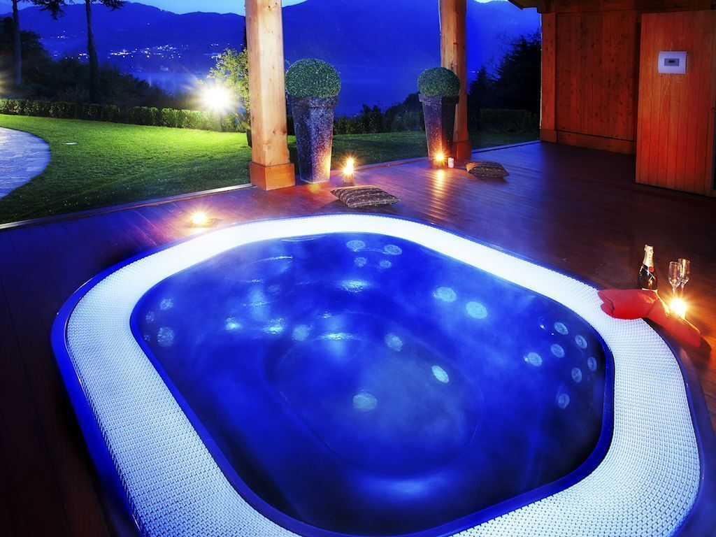 Een bubbelbad met uitzicht op bergen 's nachts.