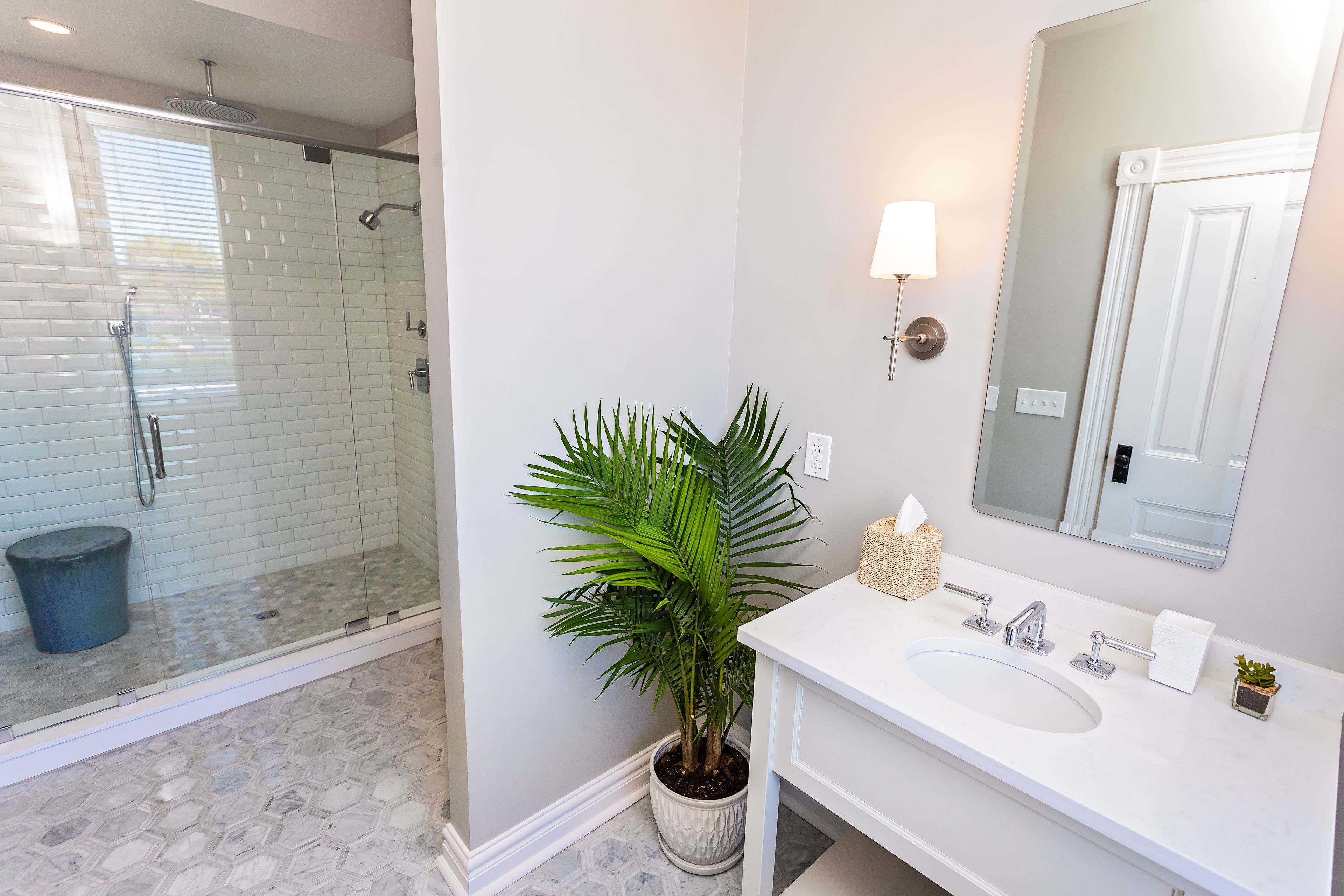 A bathroom with a shower, sink, and mirror.