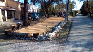 A residential driveway with a gravel path, a stone border, and a parked car.