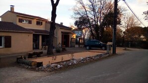 A residential area with a house, a parked car, and a stone pathway.