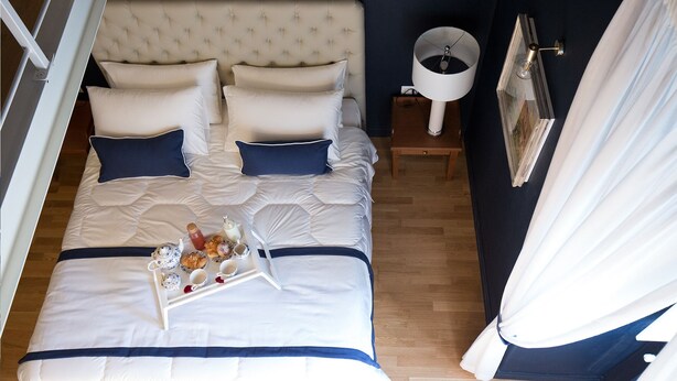 A neatly made bed with a tray of breakfast items, a bedside table with a lamp, and a framed picture on the wall. - Villa Klaudia - charming house_ Pompeii (San Giorgio a Cremano)