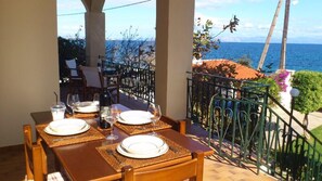 A dining table set for two with a view of the sea.
