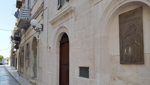 Un edificio con una placa que dice “Edward Rooms & Wellness” y una puerta con un pequeño ventanal.