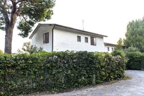 A single-story building with a white exterior, a tiled roof, and a small antenna on the roof.
