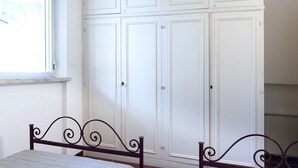 Une chambre à coucher avec un lit, une armoire et une fenêtre.