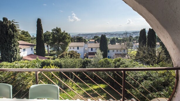 Un balcon donnant sur un quartier résidentiel, avec vue sur des maisons et des arbres.