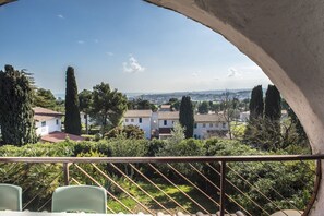 Un balcón con vista a una zona residencial, con casas y árboles.