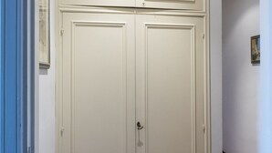 Une porte à double battant fermée, avec un trou de serrure, un chambranle bleu et un petit tableau encadré accroché au mur.