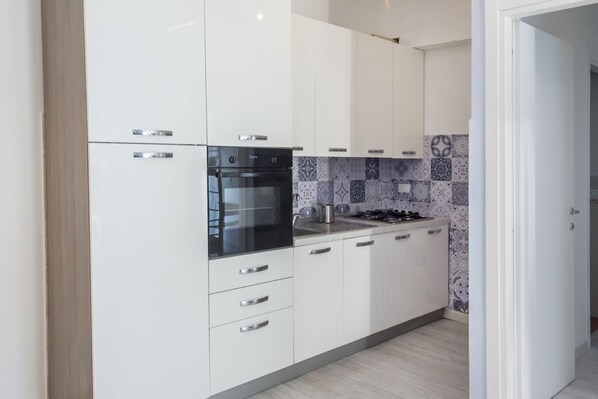 Een koelkast, een oven, een vaatwasser, eettafels