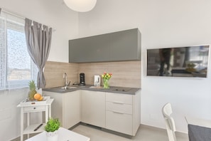 Enjoy meals and entertainment in this kitchen with a sink, flat-screen TV, and dining area.