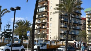 A multi-story building with balconies, a stone wall in the foreground, and palm trees. - Nice apartment, in front of the beach. (Fuengirola)