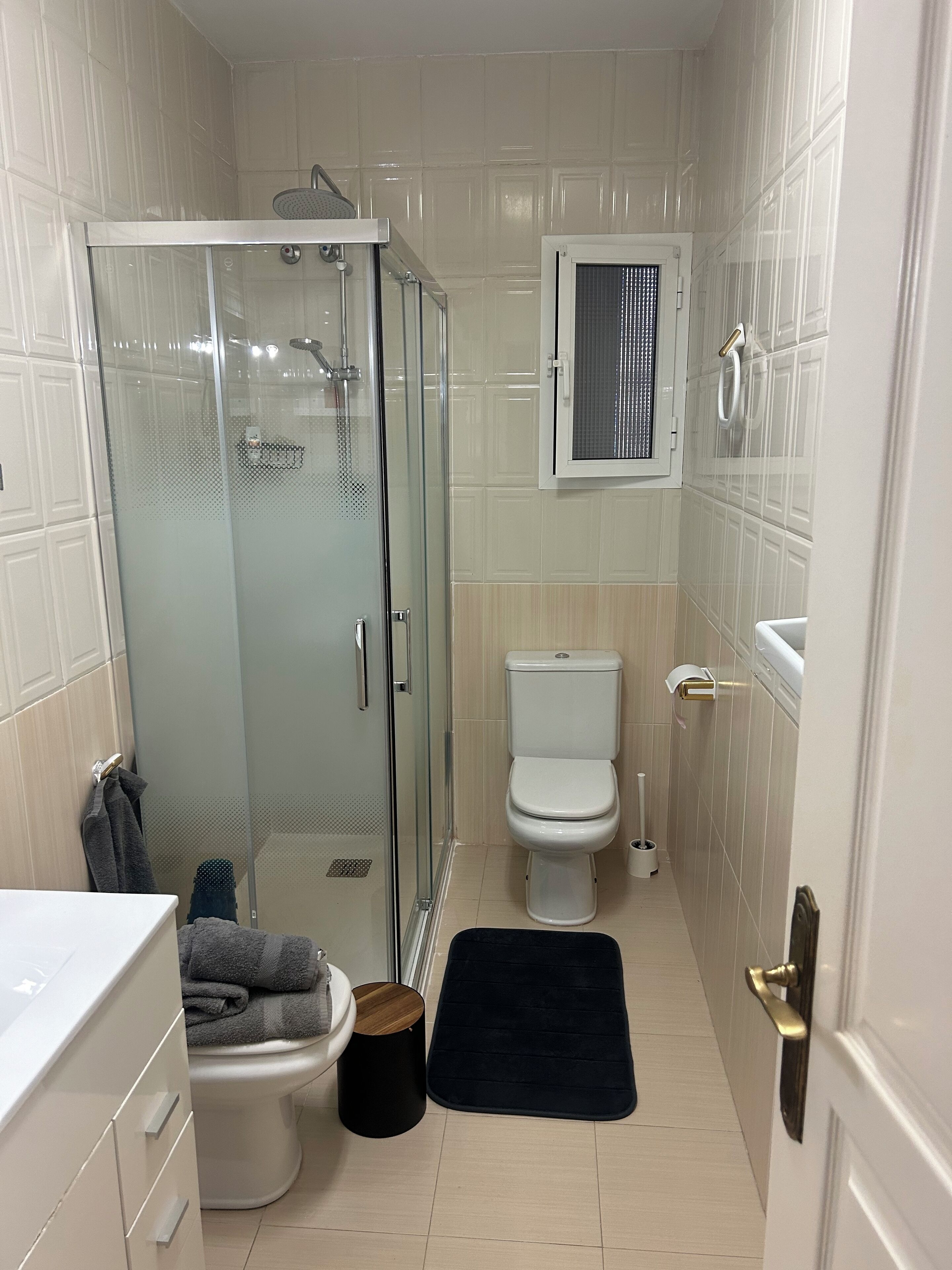 Une salle de bain compacte avec une douche à parois de verre, des toilettes et un lavabo.