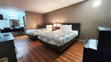 Una habitación de hotel moderna con una cama grande, mesitas de noche, un escritorio y un baño a la vista a través de una puerta abierta.