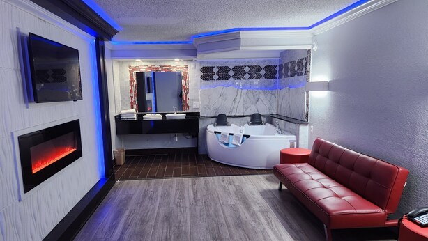 A modern bathroom with a vanity, a bathtub, and a red leather bench.