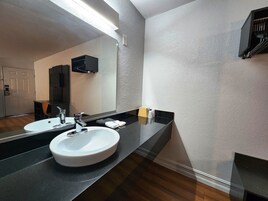 Un baño moderno con un espejo grande, dos lavamanos y una encimera negra.