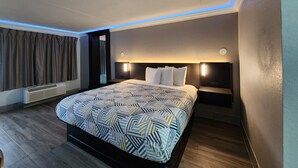 A modern hotel room with a large bed, a built-in heater, and a view of the city.