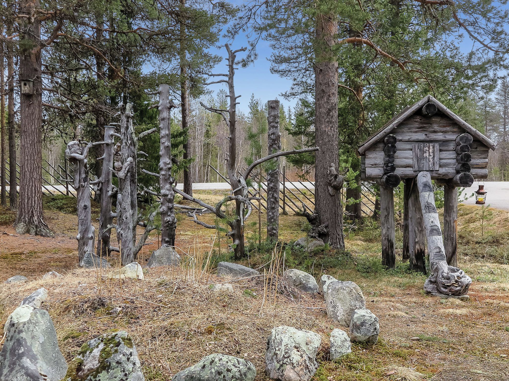 A rustic wooden cabin surrounded by trees and rocks.