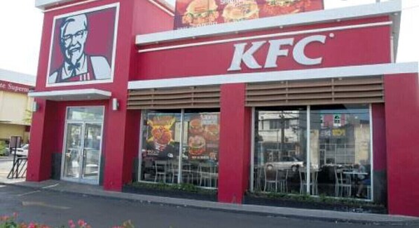 A KFC restaurant with a red exterior and large windows.