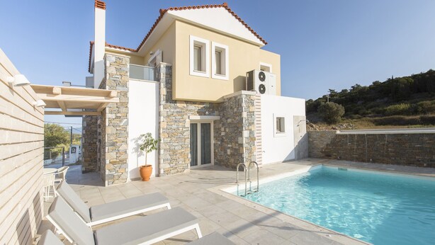 A modern house with a swimming pool, stone walls, and a tiled patio. - Virginia Luxury Villas (Samos)