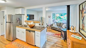 A modern kitchen with stainless steel appliances, a wooden countertop, and a dining area with a sofa and rug. - House w/ Deck on Whidbey Island, 1 Mi from Shore! (Clinton)